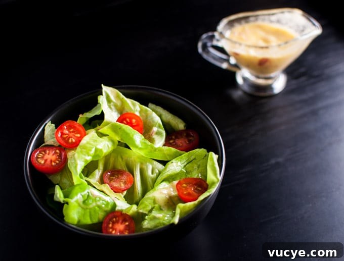 black salad bowl with iceberg lettuce, tomatoes, and the best vinaigrette