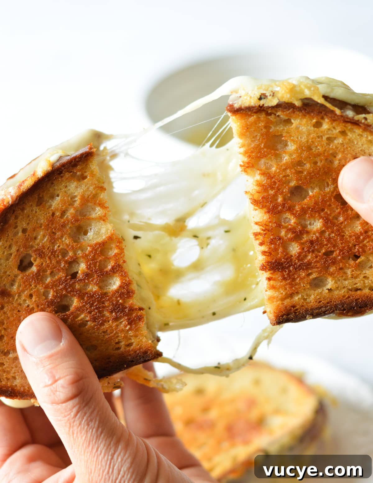 hand pulling apart a grilled cheese. 