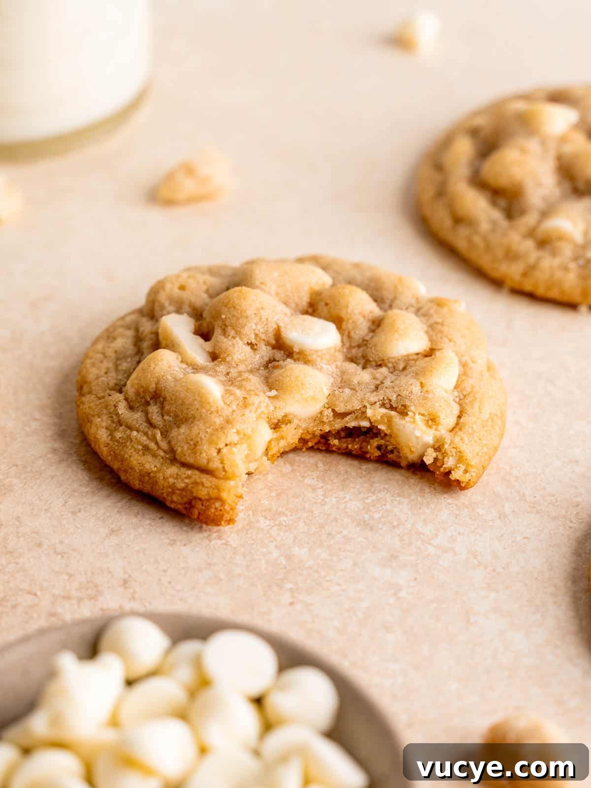 White Chocolate Macadamia Nut Cookies Recipe You’ll Love 8 A white chocolate chip macadamia nut cookie with a bite taken out of it.