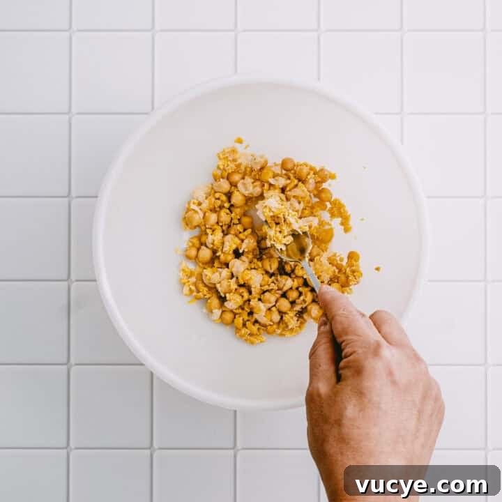 Mashed chickpeas in a bowl for making chickpea flatbread.