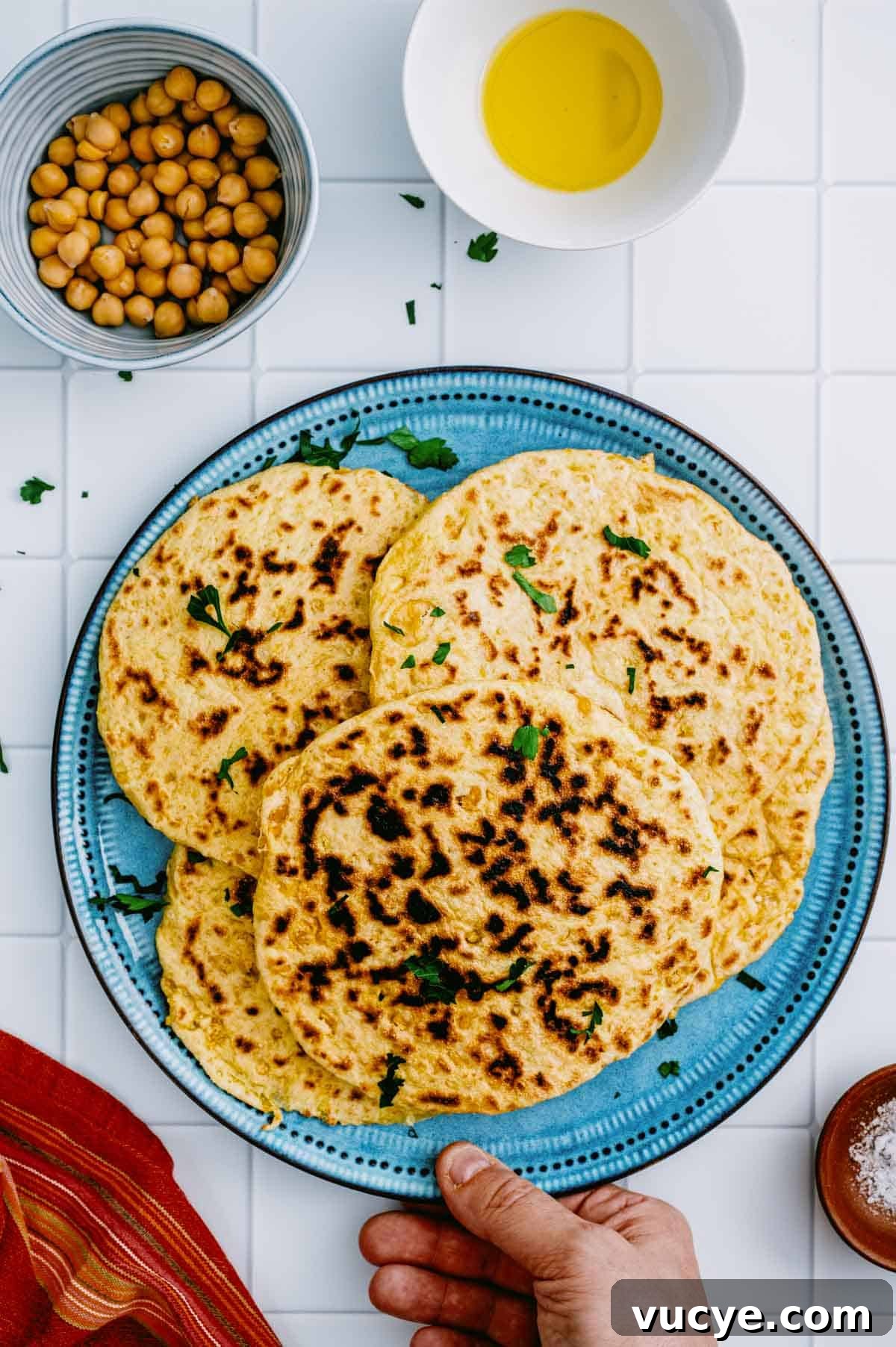 Stack of homemade chickpea flatbreads on a blue plate.
