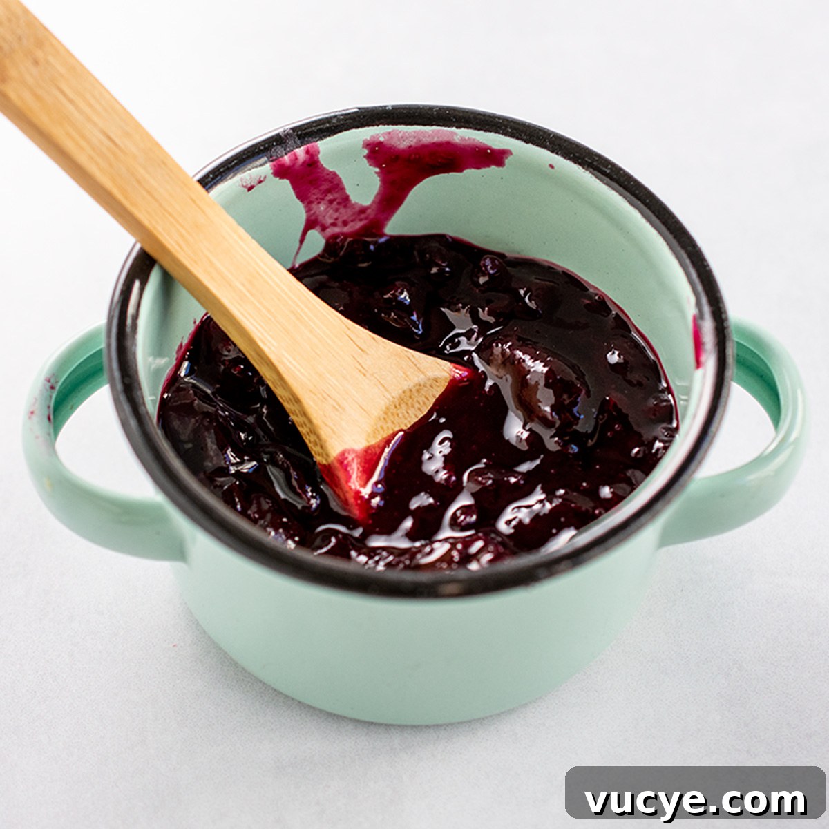 Mini Cherry Hand Pies: Bite-Sized Fruit Pastries Recipe 6 Mini cherry pie filling in turquoise bowl with wooden spoon.