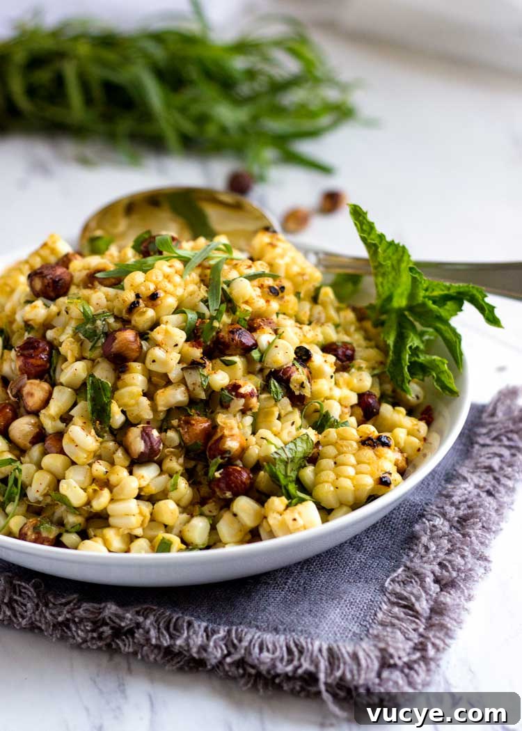 a plate of grilled corn salad with hazelnuts and fresh herbs
