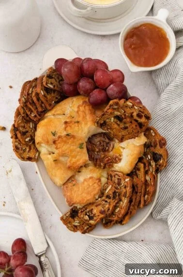 Classic Gluten-Free Apple Pie Recipe for Perfect Autumn Baking 12 Gluten-free baked Brie on a platter with gluten-free crackers and grapes.