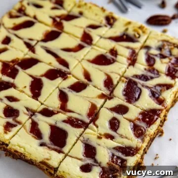 Baked and sliced keto cheesecake bars with sugar-free strawberry jam swirl.