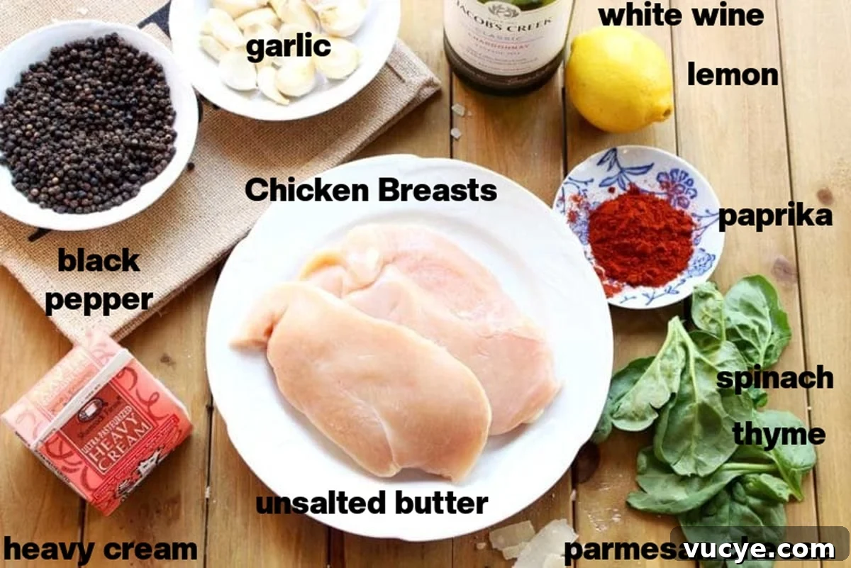 Black pan containing 3 Lemon Butter Chicken Breasts, crossed spoons and lemon slices on table.