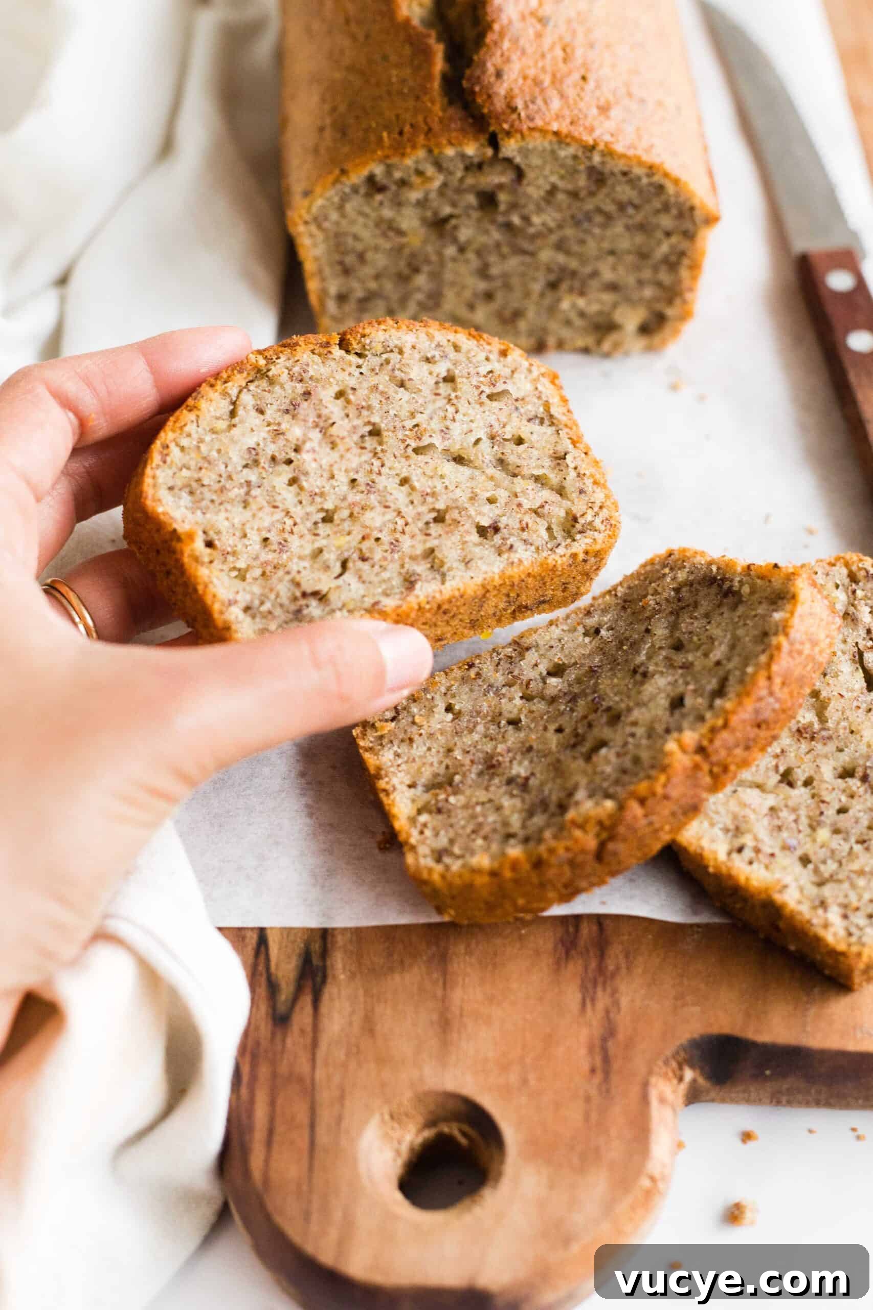 Easy Flaxseed Bread (Gluten-Free, Dairy-Free) Hand holding a slice of flaxseed bread.