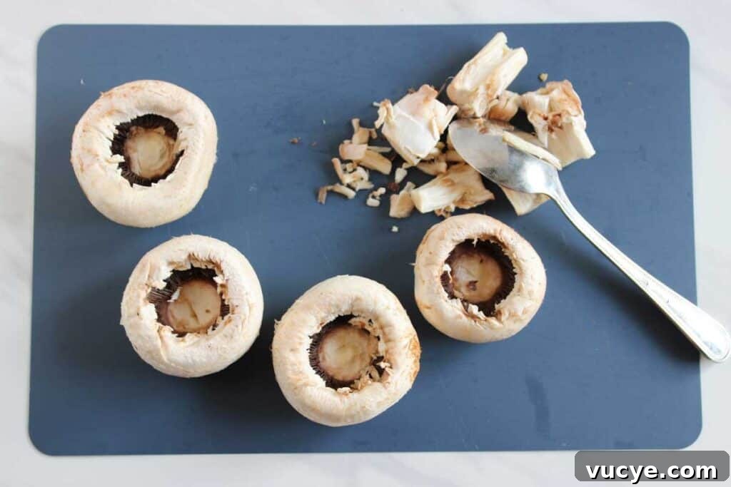 Italian-Style Stuffed Mushrooms with Garlic & Parmesan 4 scooping out mushrooms with spoon