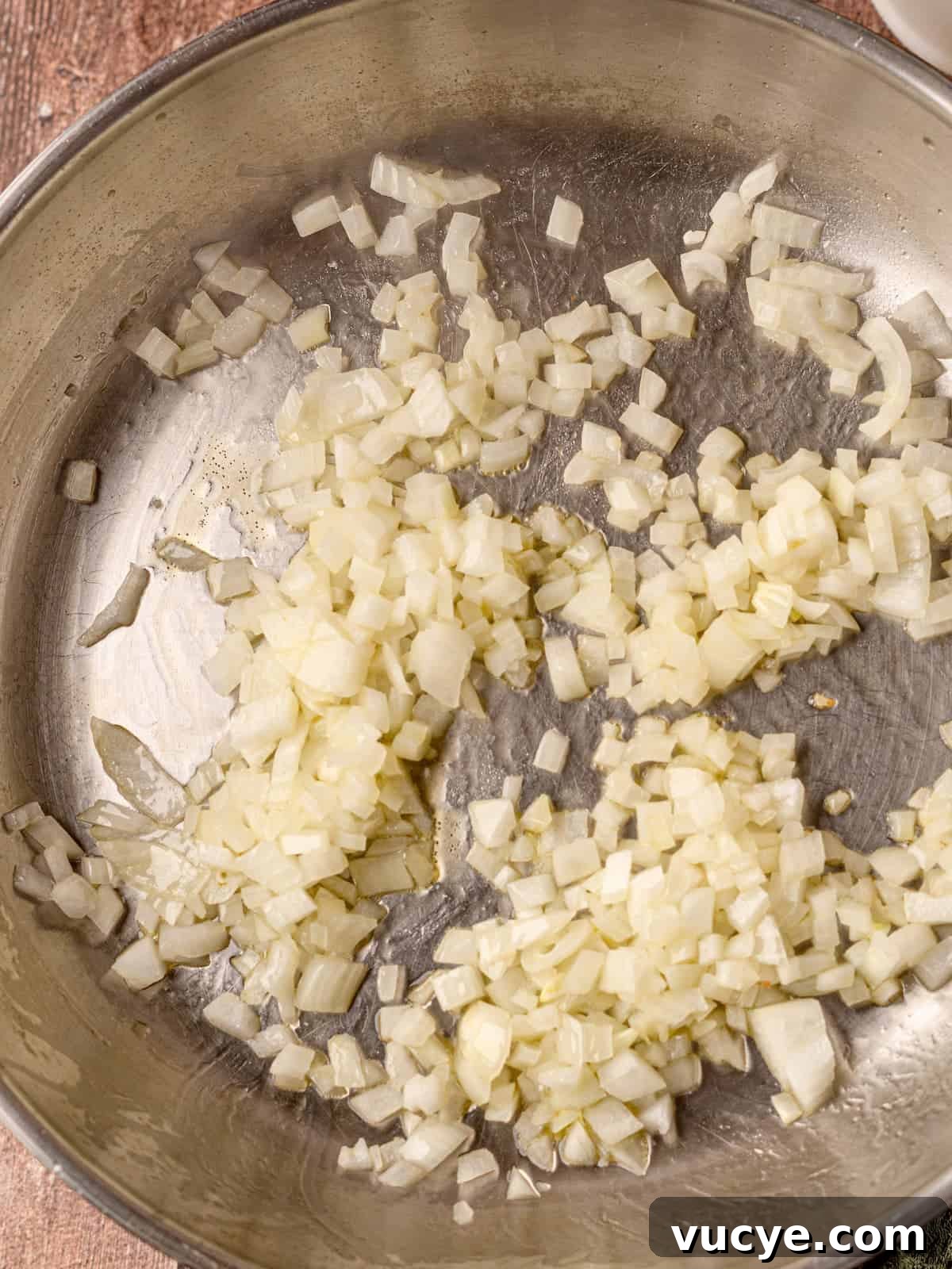 Onion being cooked in a skillet.