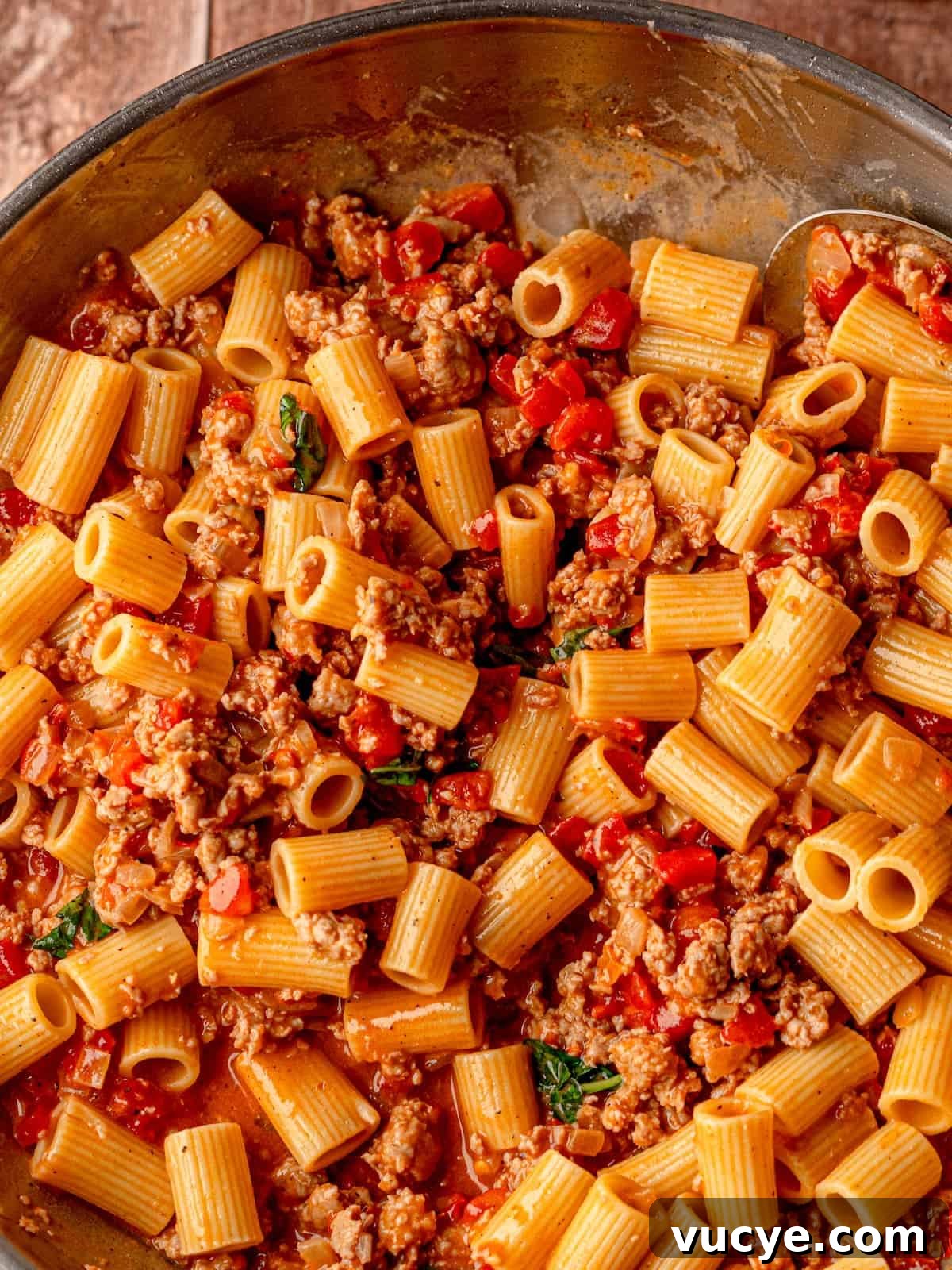 Pasta in a pan with sausage.