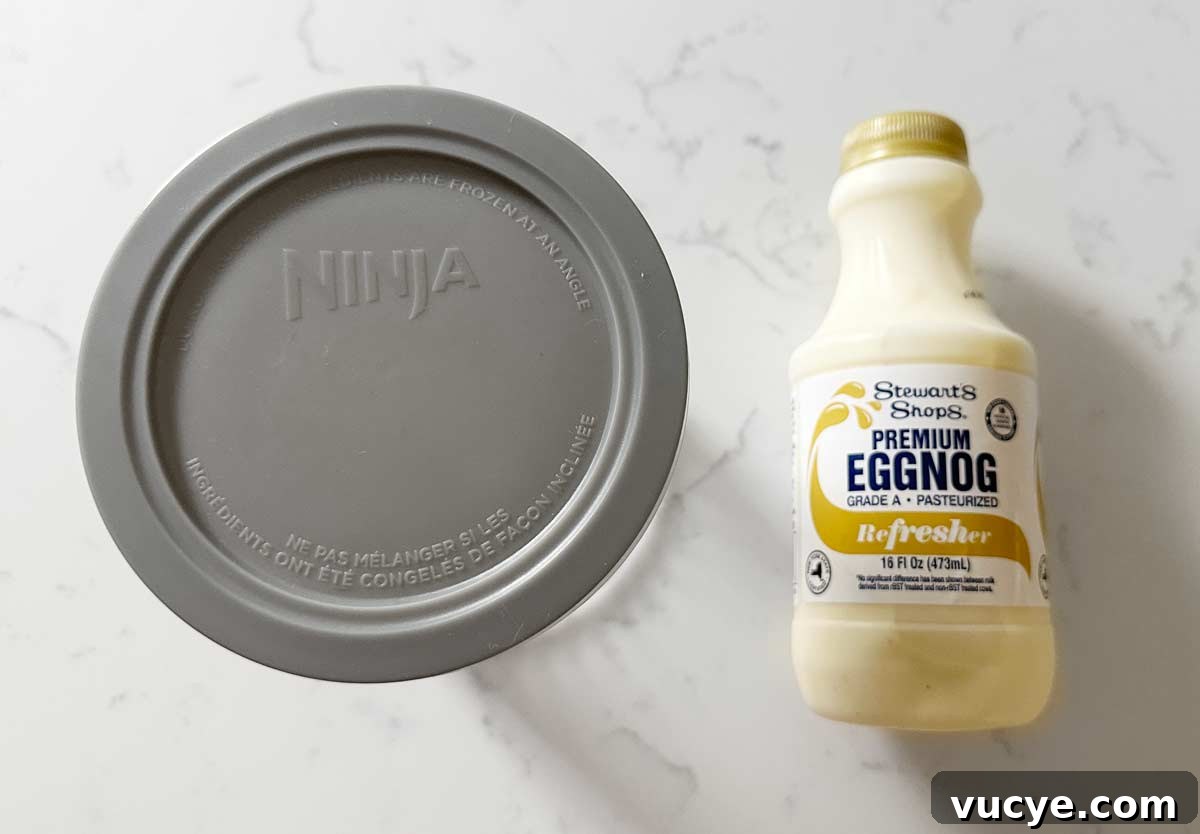 Eggnog and a ninja ice cream pint on a kitchen counter. 