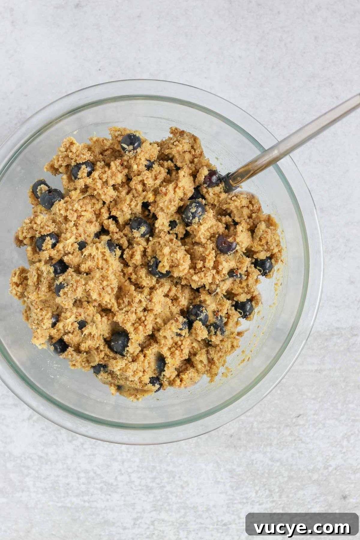 Almond flour blueberry bread batter in a mixing bowl with a spatula.