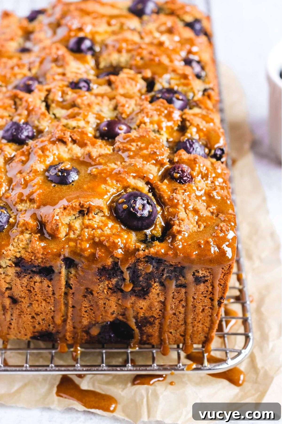 Almond flour blueberry bread loaf drizzled with coconut sugar glaze.