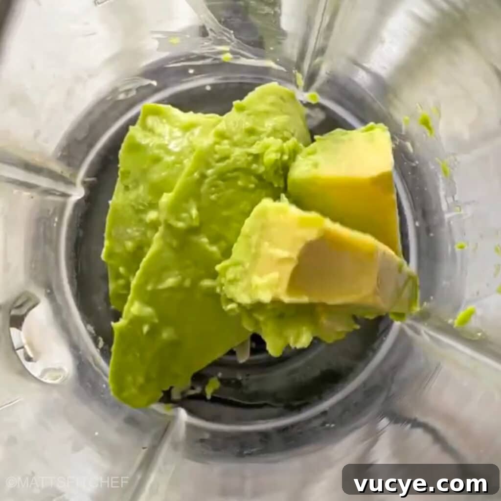 Diced avocados in a blender, ready to add cocoa powder and maple syrup before blending.
