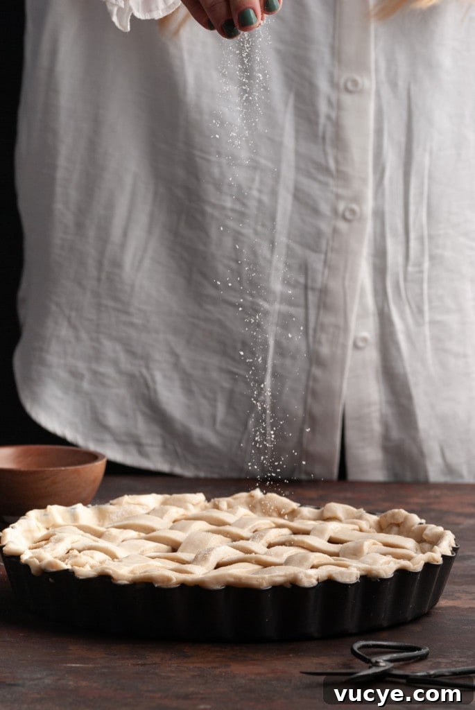 Bourbon-Drizzled Drunken Apple Pie Recipe 12 Sprinkling sugar on top of apple pie top crust.