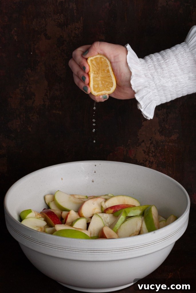 Bourbon-Drizzled Drunken Apple Pie Recipe 8 Squeezing lemon juice over sliced apples.