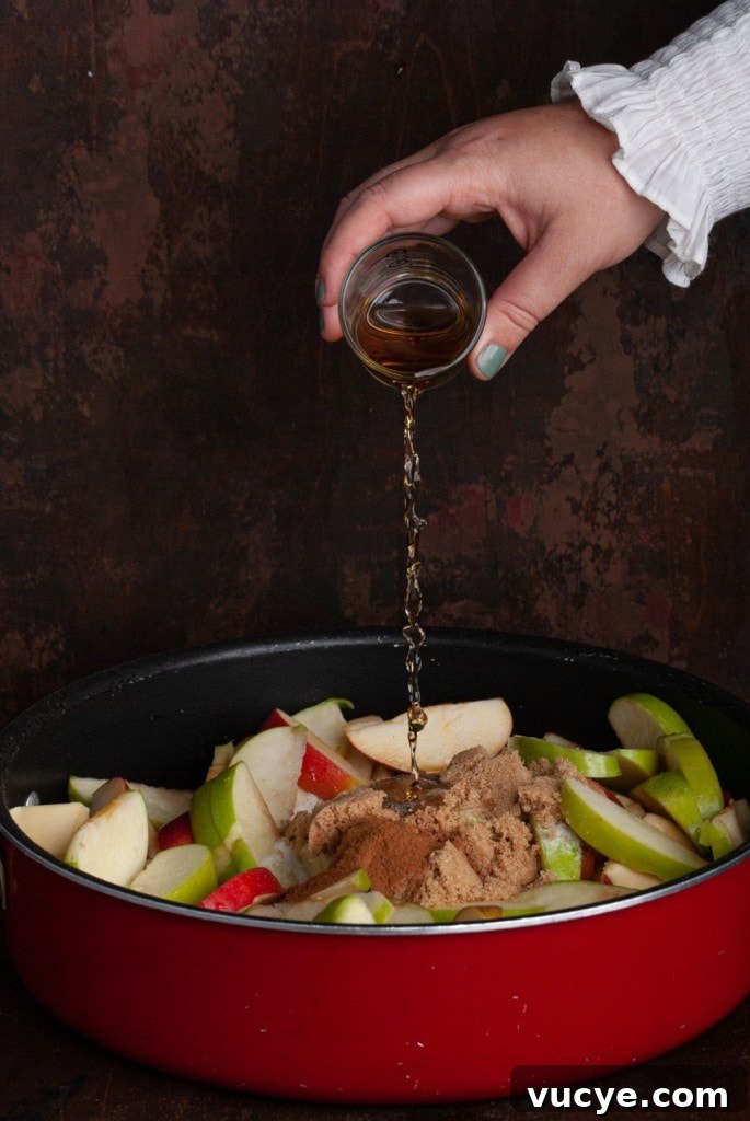Bourbon-Drizzled Drunken Apple Pie Recipe 9 Adding bourbon to apple pie filling.