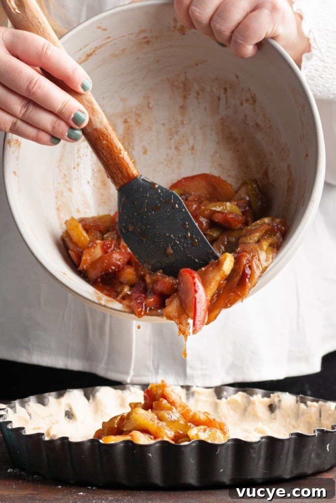 Bourbon-Drizzled Drunken Apple Pie Recipe 10 adding apple pie filling into pie crust