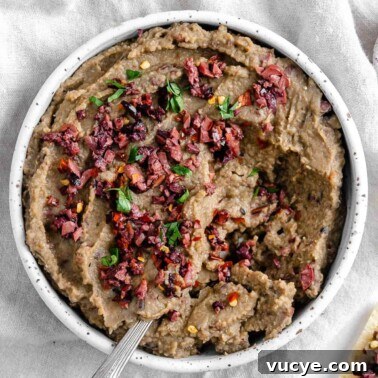 completed Spicy Lentil Kalamata Dip in a white bowl against a white background