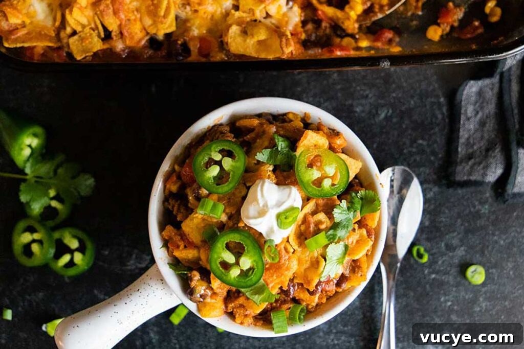 Cheesy Frito Pie Casserole with Chili and Corn Chips 9 Frito pie casserole in a white bowl