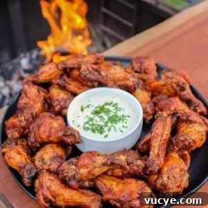 overhead of a plate of smoked double fried wings next to a grill