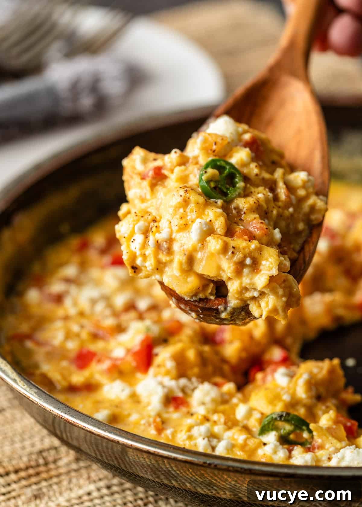 closeup: a wooden spoon serving Turkish scrambled eggs from a skillet
