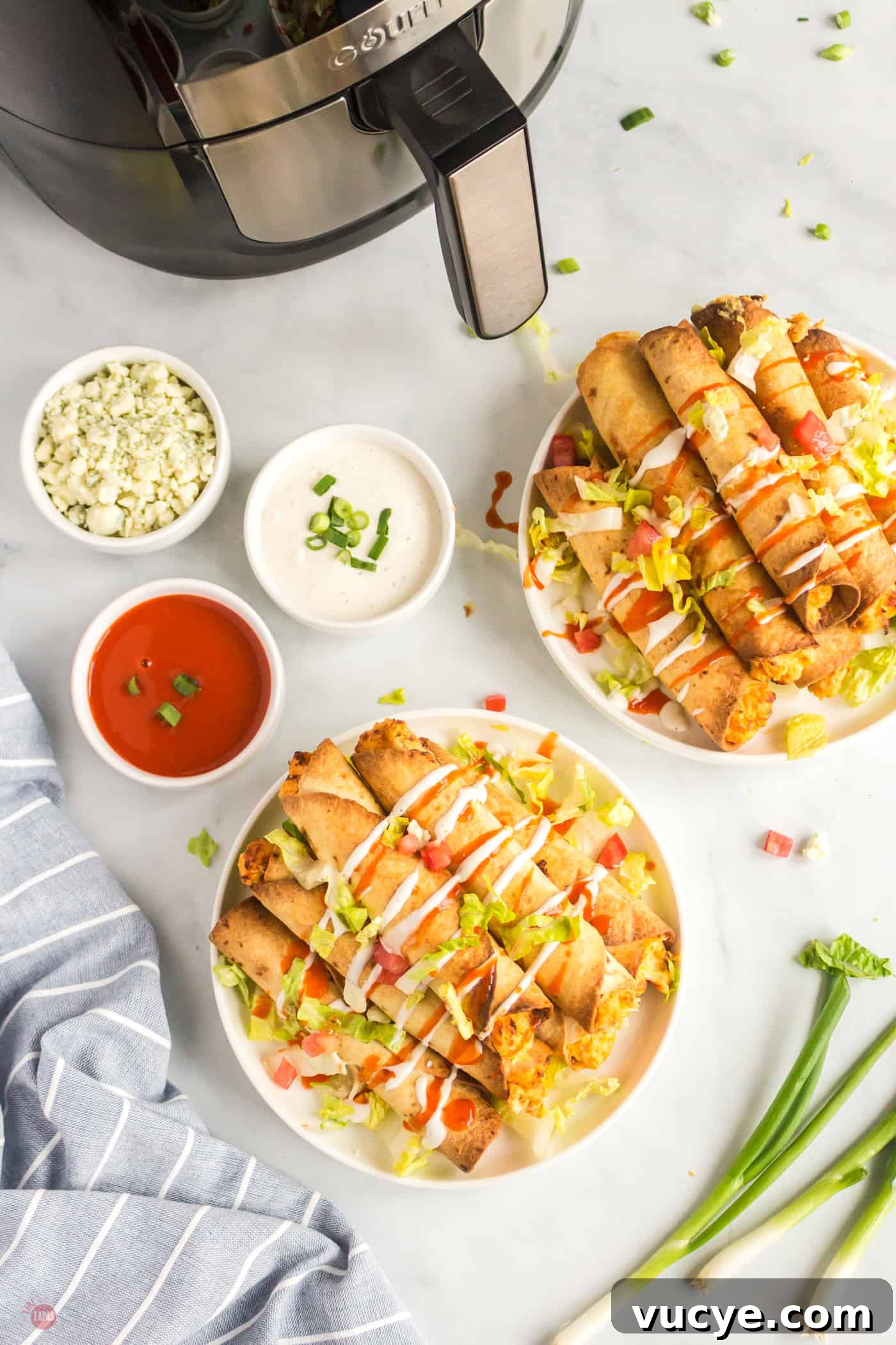 overhead picture of two plates of taquitos