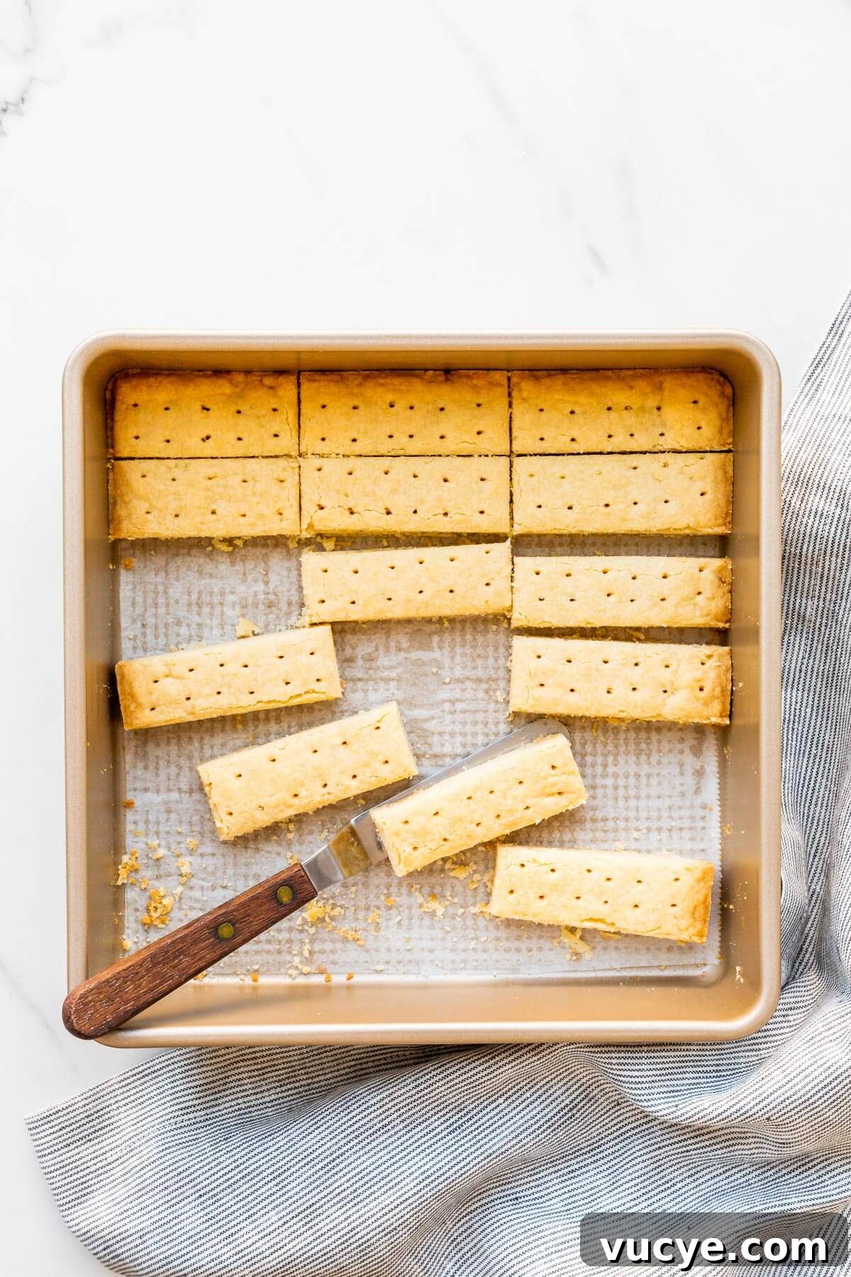 Shortbread cookies cut into sticks being served from the square pan they were baked in.