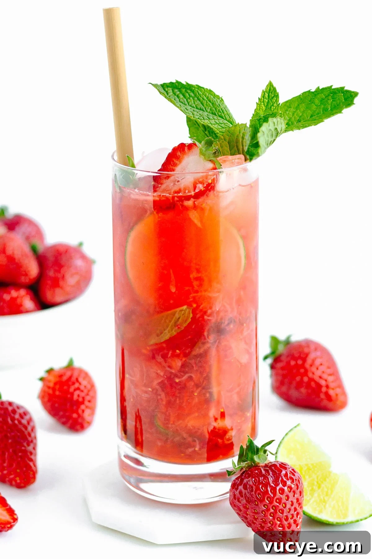 Must-Try Strawberry Recipes for Every Season 11 Tall glass of strawberry mojito mocktail surrounded by strawberries and lime.