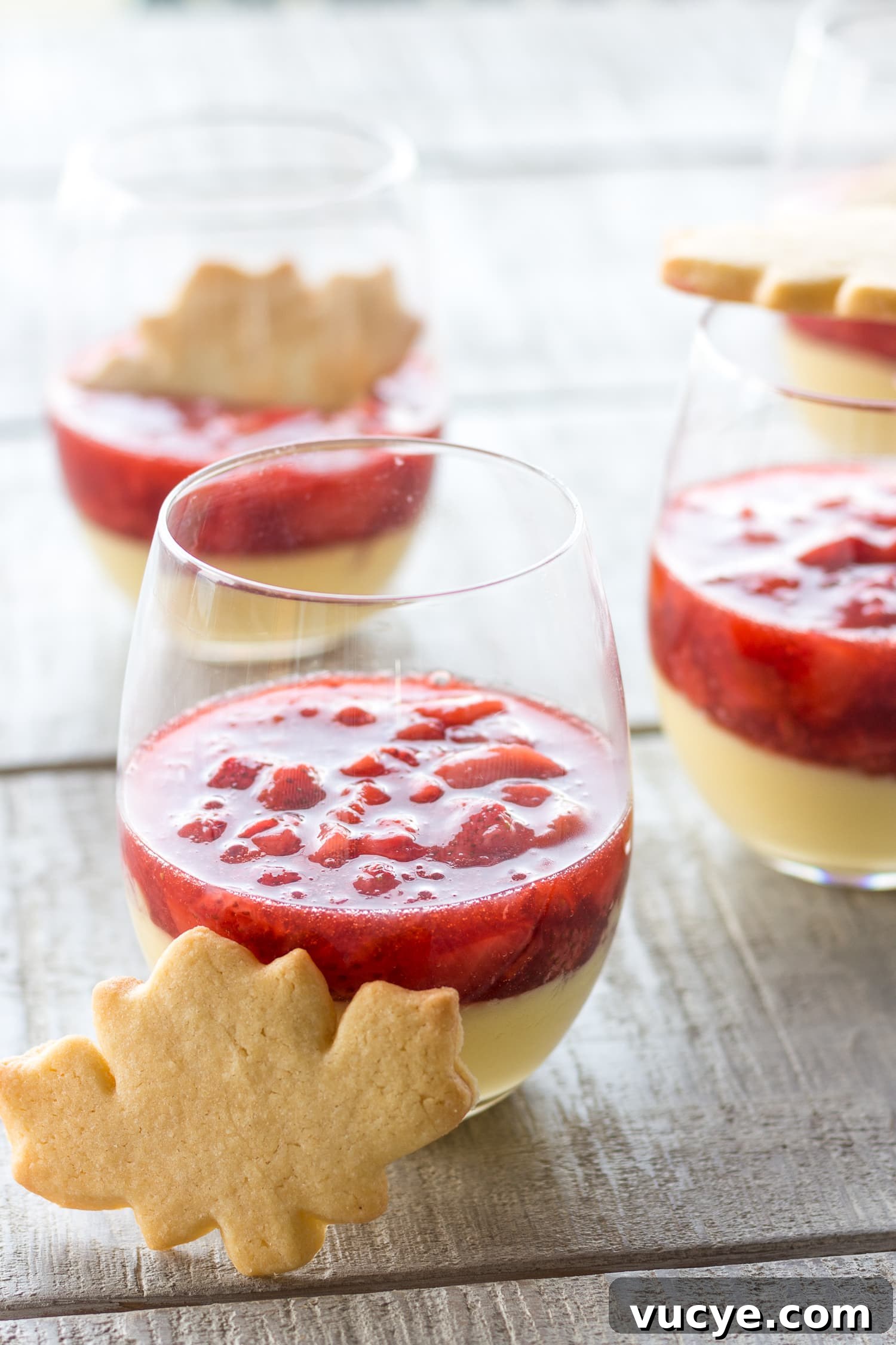 Must-Try Strawberry Recipes for Every Season 12 Three glasses of maple custard topped with strawberry compote and garnished with a maple leaf shaped sugar cookie.
