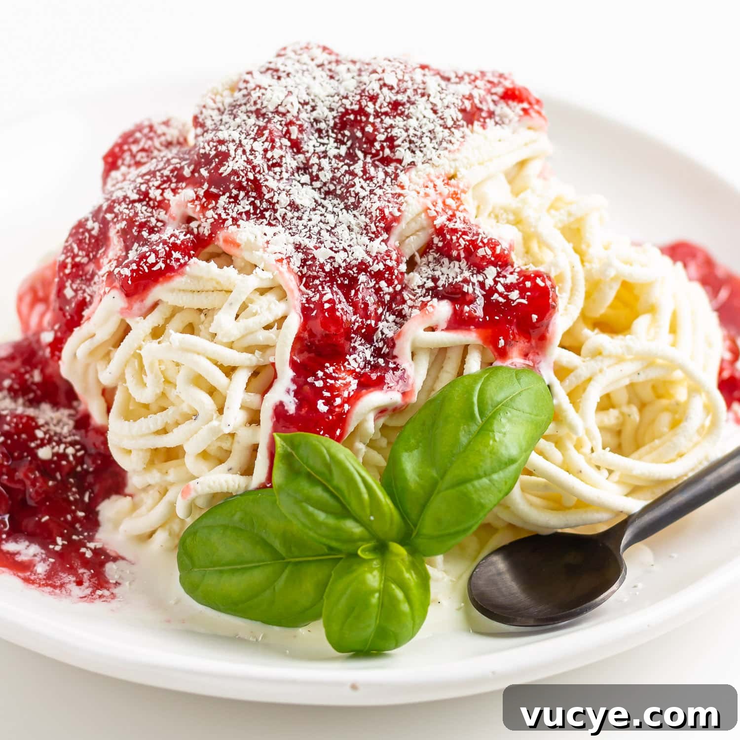 Must-Try Strawberry Recipes for Every Season 14 Spaghetti-Eis on a white plate with sprig of basil and a black spoon.