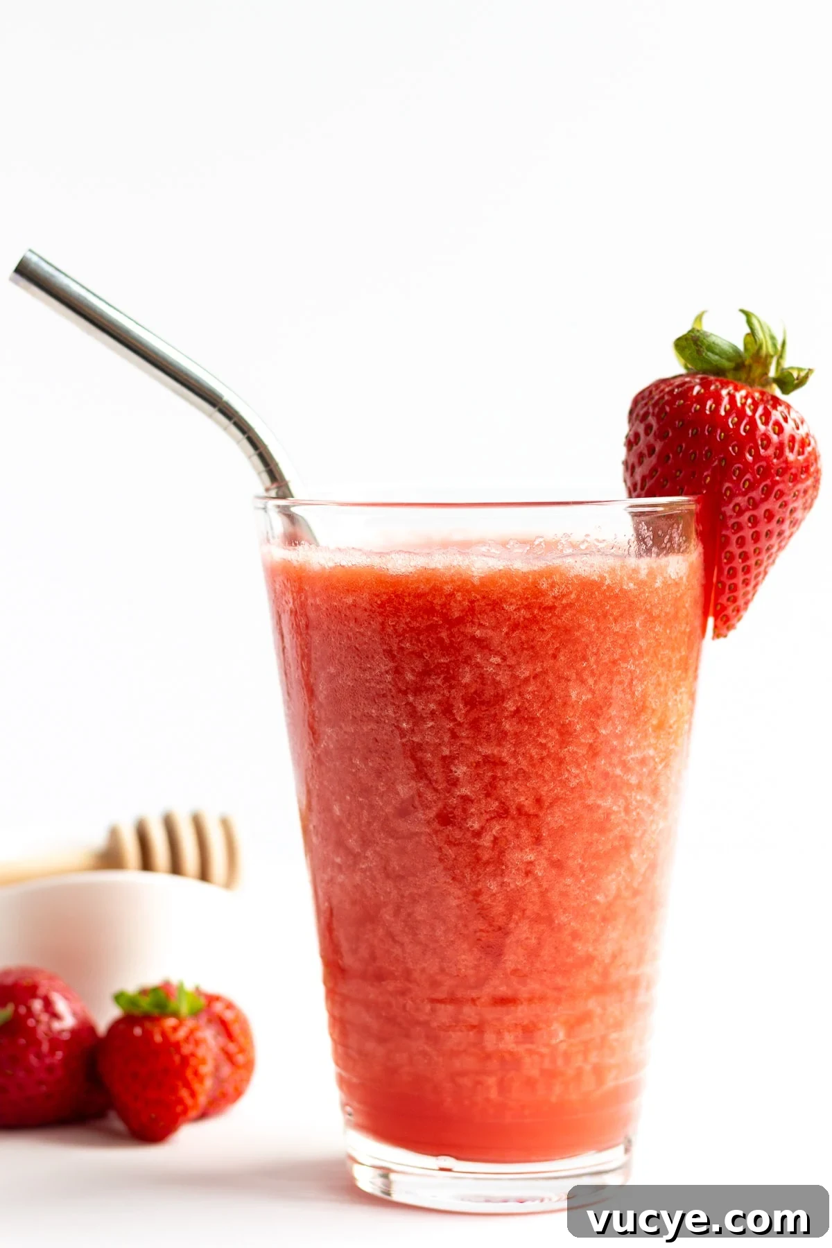 Must-Try Strawberry Recipes for Every Season 8 Glass of strawberry slushie garnished with a strawberry and stainless steel straw.