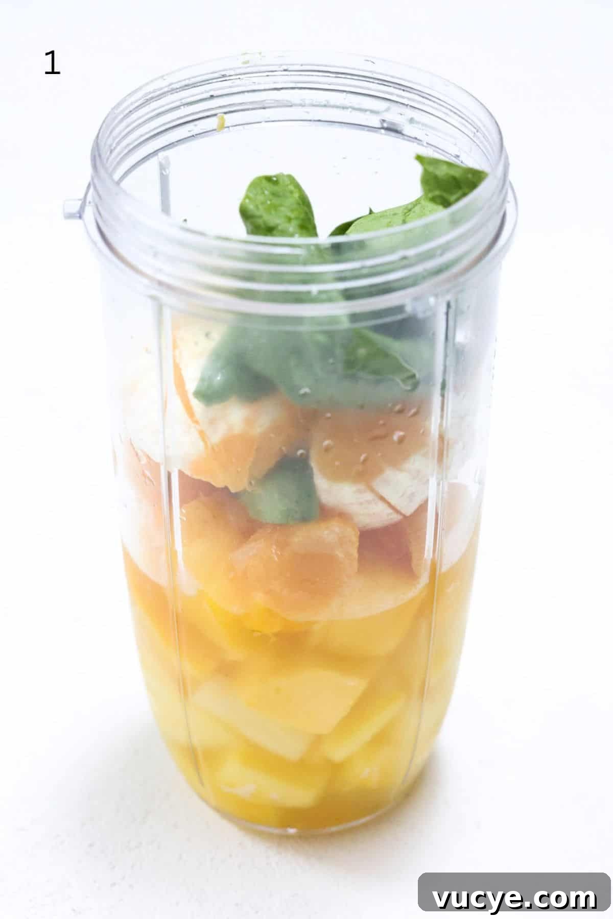 Island Green Tropical Smoothie Recipe — Refreshing Pineapple & Kale Blend 4 Island Green Tropical Smoothie ingredients in a NutriBullet Pro blender container.