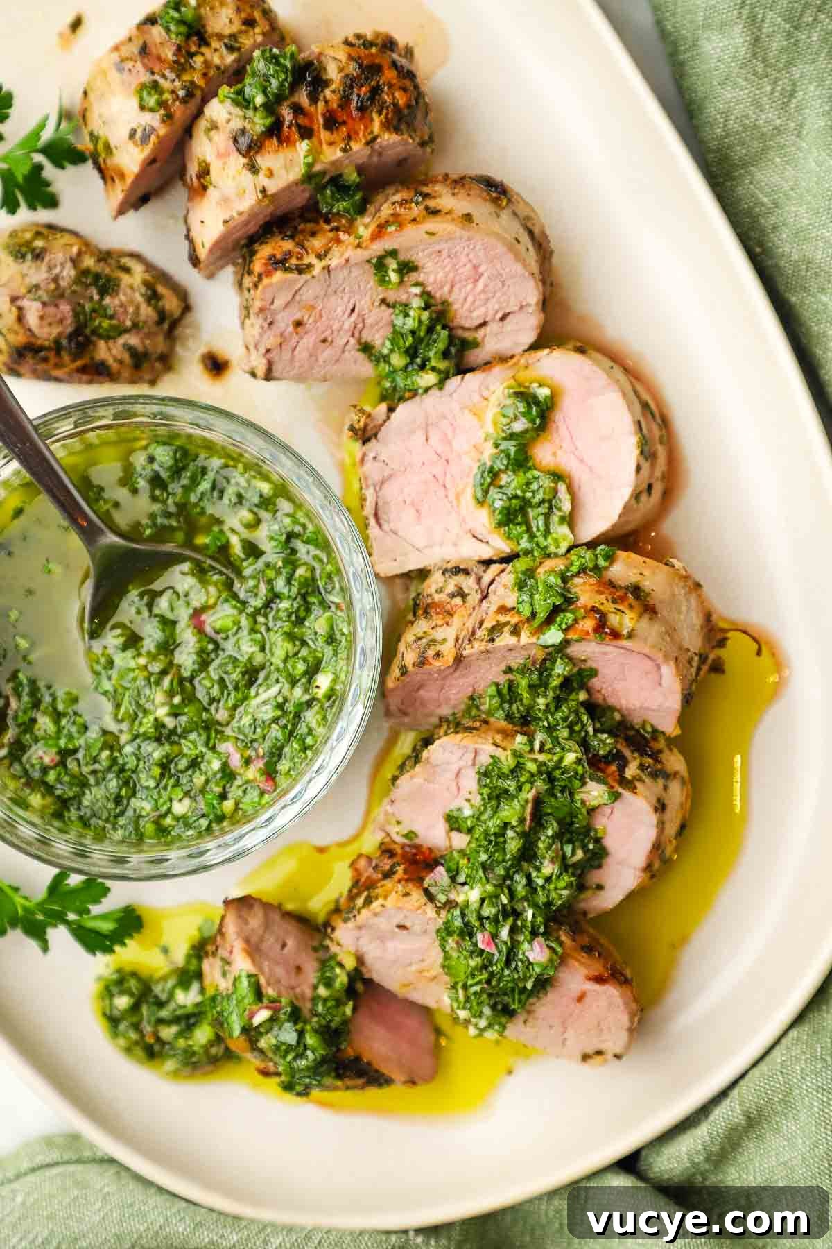 Grilled Pork Tenderloin with Chimichurri Sauce 12 A plate of sliced pork tenderloin with chimichurri on top.