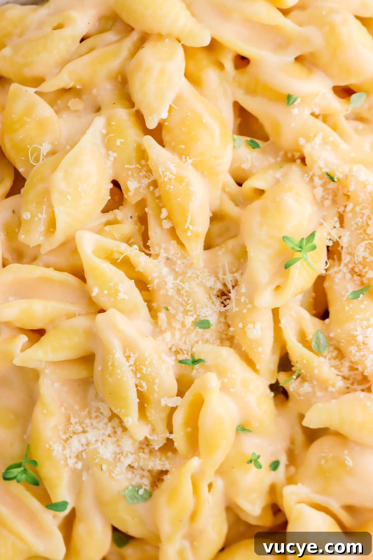 Creamy Four-Cheese Macaroni and Cheese Recipe 3 close up of macaroni and cheese with grated parmesan and thyme sprigs on top