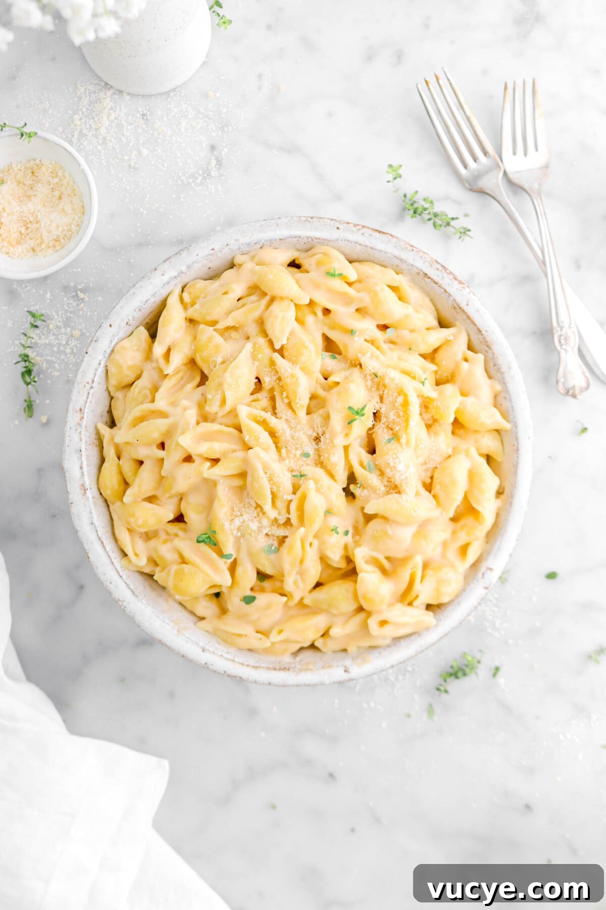 Creamy Four-Cheese Macaroni and Cheese Recipe 17 close up of bowl of mac and cheese with thyme sprigs and grated cheese on top