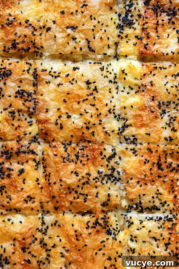 Tiropita: Authentic Greek Cheese Pie Recipe You Can Make at Home 2 Golden, flaky squares of crisp phyllo pastry, this classic Greek cheese pie—Tiropita—is topped with melted cheese and a sprinkle of black sesame seeds.