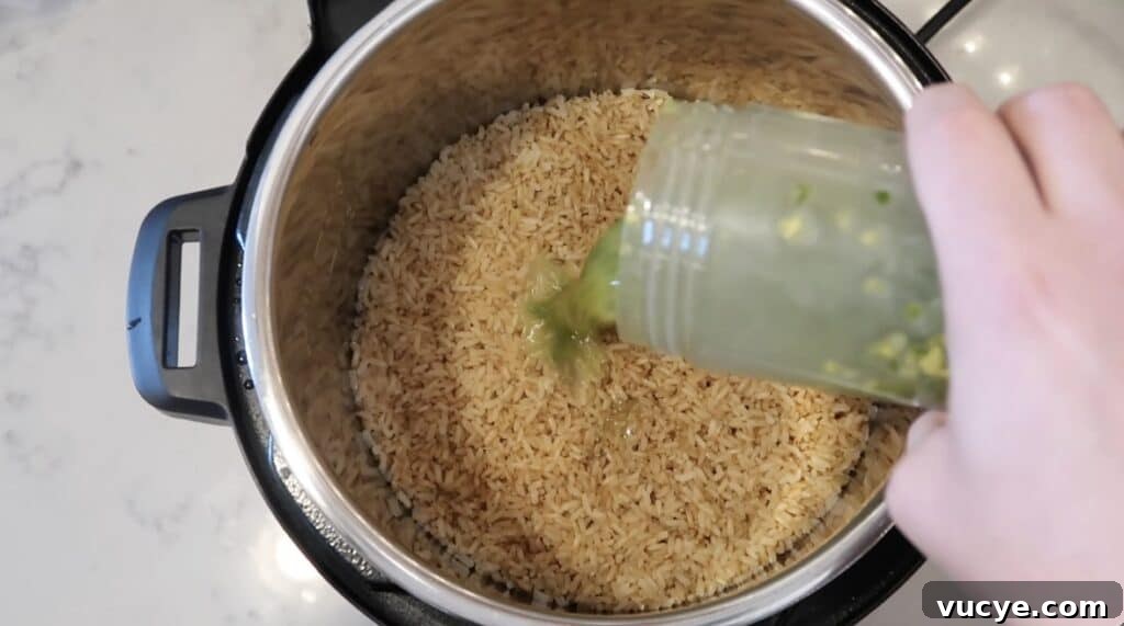 Instant Pot Ginger Scallion Chicken and Rice Bowl 16 Adding oil to rice in pot