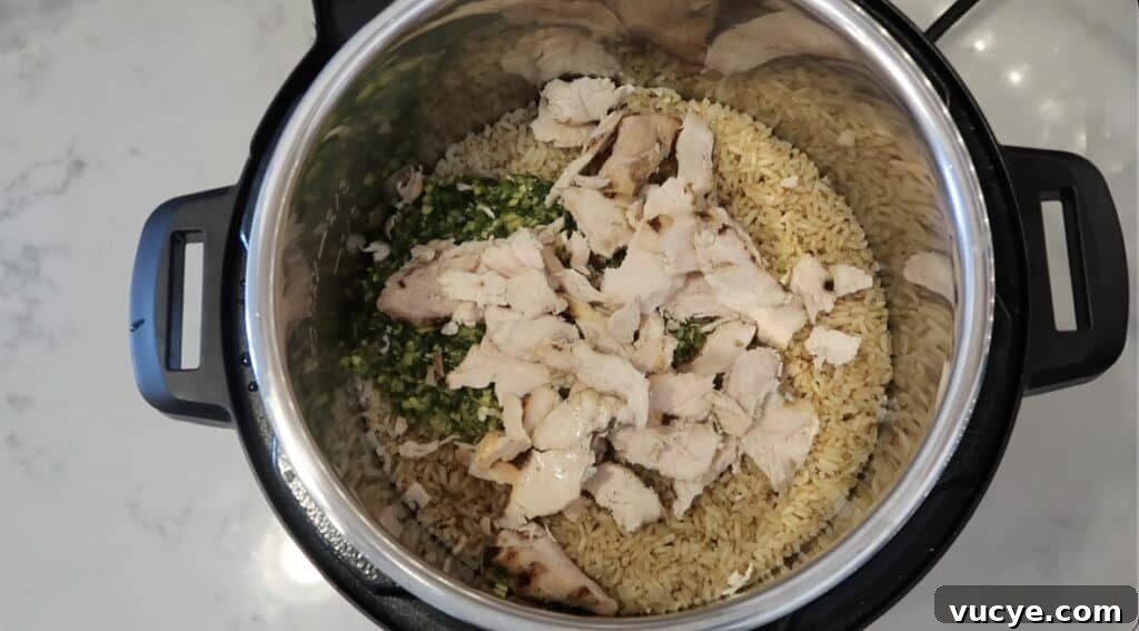 Instant Pot Ginger Scallion Chicken and Rice Bowl 17 Adding pre-cooked chicken to pot