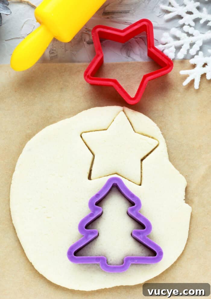 cutting out shapes using cookie cutters from the salt dough