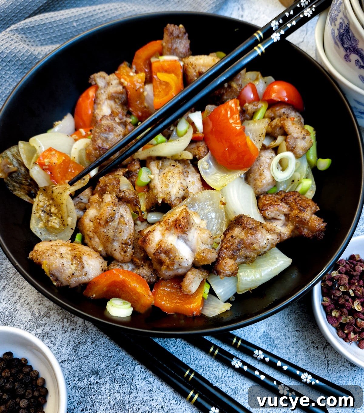 Crispy Salt and Pepper Chicken Recipe for Dinner 2 A black serving dish containing salt and pepper chicken. There are black chopsticks in the dish.