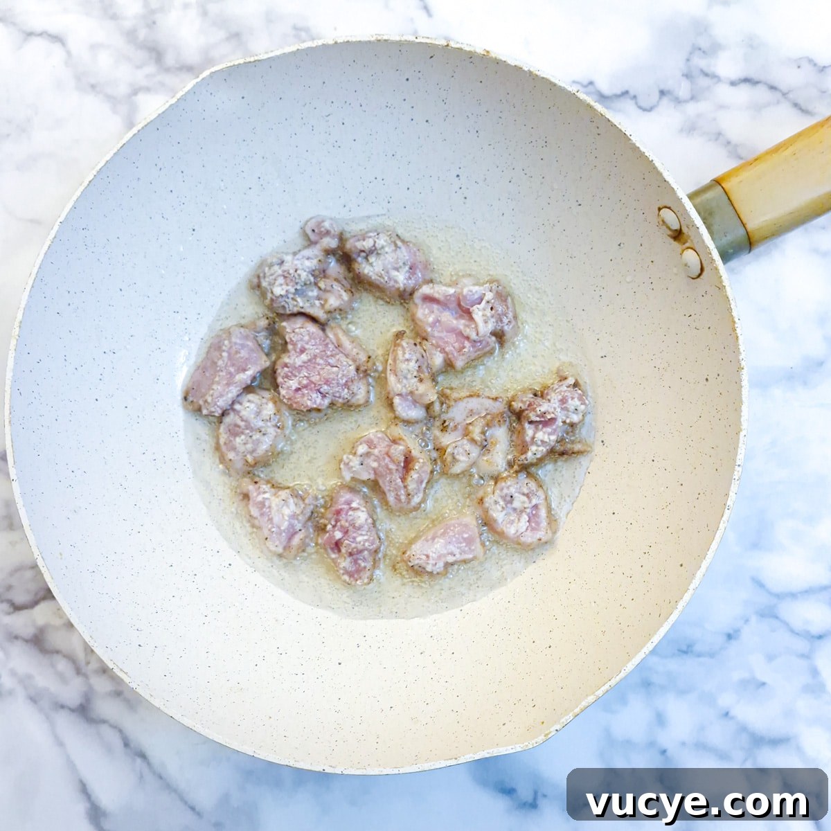 Crispy Salt and Pepper Chicken Recipe for Dinner 9 Chicken pieces frying in a wok.