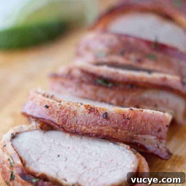 Double-Smoked Ham Techniques for Rich, Smoky Flavor 14 Bacon wrapped pork tenderloin cut into slices on wood cutting board with cilantro and lime garnish