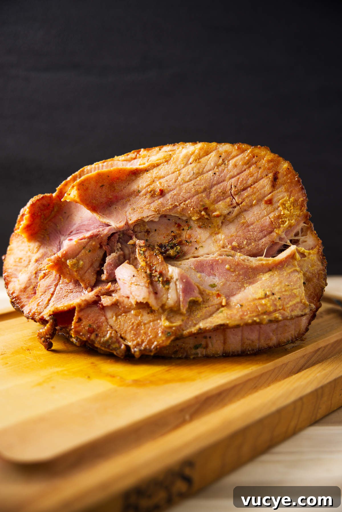 Double-Smoked Ham Techniques for Rich, Smoky Flavor 3 Spiral sliced twice smoked ham resting on butcher block.