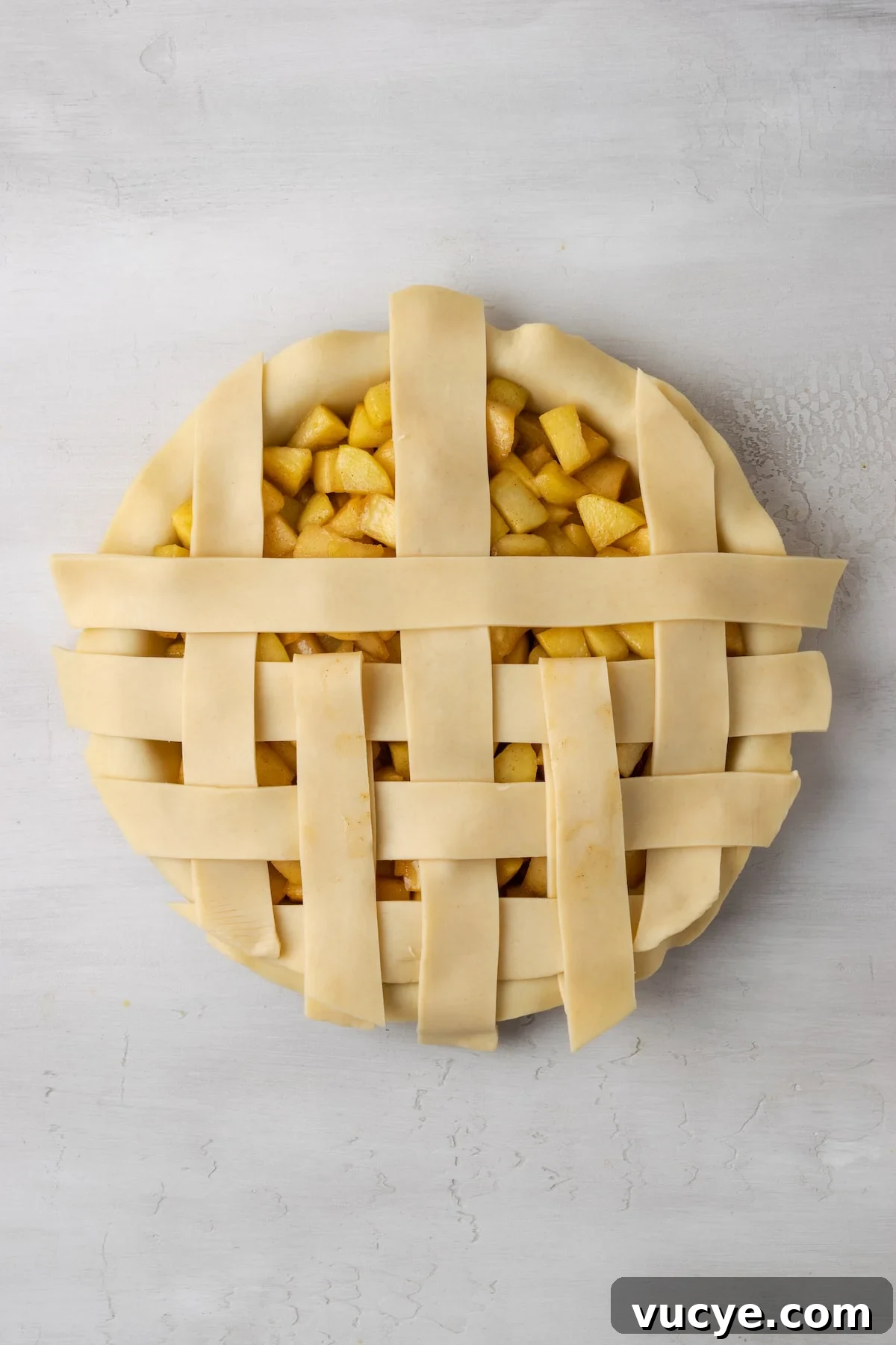 Repeat. An apple pie with a partially completed lattice top.