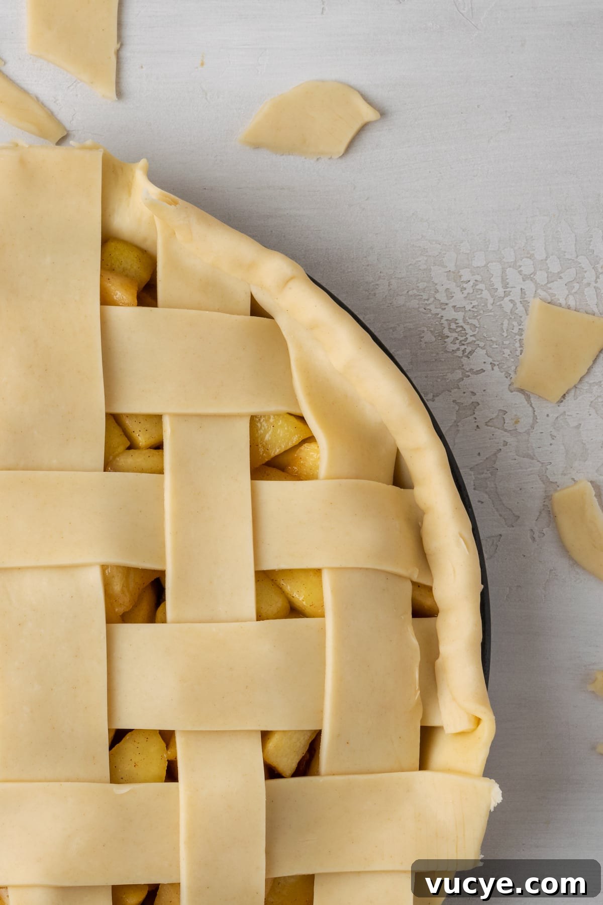 Trim the ends. Close up of an apple pie with a lattice top with the ends of the lattice strips trimmed.