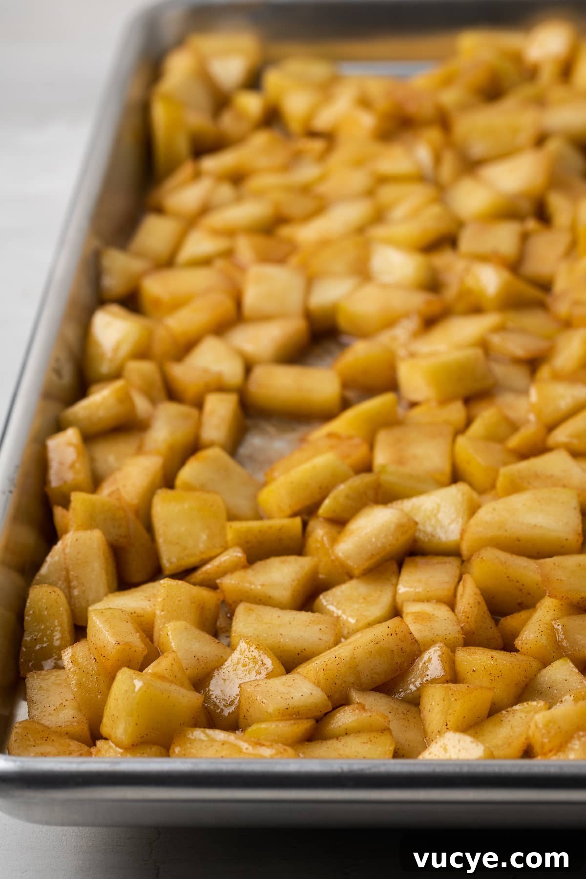Cook the filling. Caramelized apples spread out in a single layer on a baking sheet.