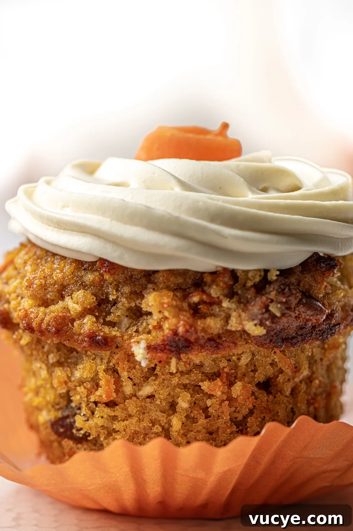 Low-Carb Carrot Cake Muffins with Cream Cheese Frosting 5 A close up image of a muffin with the wrapper pulled down.
