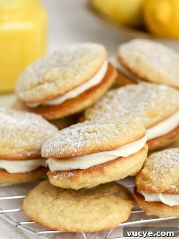 A batch of lemon whoopie pies on a rack.