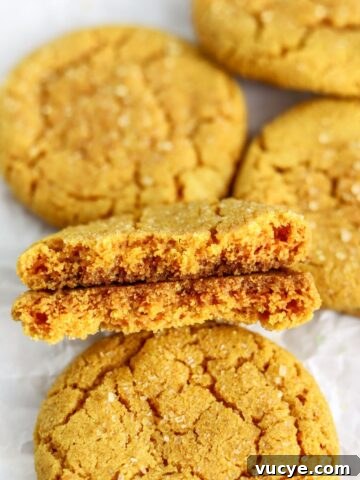 Golden turmeric cookies split in half on parchment paper.